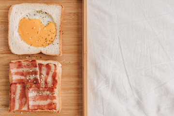 Easy and simple breakfast set of Bacon Sandwich served with black coffee on bed.