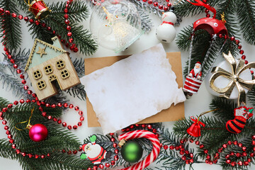 christmas greeting card mockup. fir branches with Christmas decorations and an envelope with a white blank for text