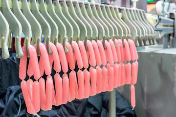 Fototapeta premium sample imitate sausage stuffer put in collagen casings during hanging on hanger of automatic line conveyor machine holder for transport in manufacturing process food industrial