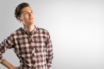 Portrait shot of young adult man smiling posturing on background
