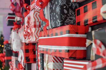 Wall of many Christmas gift boxes for festive background. Selective focus. 