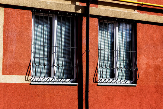 Windows in a wall with figured forged metal bars. Robber protection. Safety of life in the city