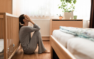 Tired, exhausted, mother, wife at home sitting on bedroom floor.	 - obrazy, fototapety, plakaty
