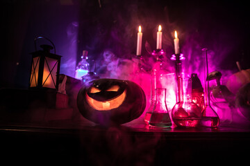 Halloween still-life background with different elements on dark toned foggy background. Selective focus