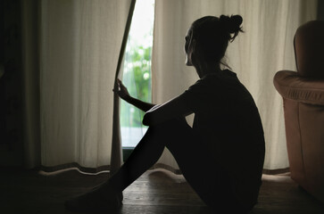 Thoughtful girl sitting at home looking out window, sad depressed teenager spending time alone at home, young upset pensive woman feeling lonely or frustrated thinking about problems