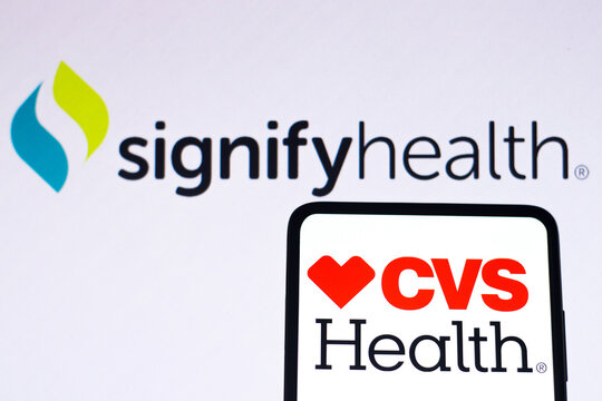 September 7, 2022, Brazil. In this photo illustration, the CVS Health logo is displayed on a smartphone screen and the background the Signify Health logo.