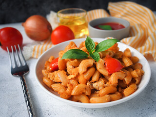 Macaroni pasta with tomato sauce on white wooden table