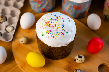 Decorated Easter cake and colorful painted eggs on table at home.