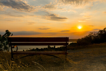 Fototapeta premium Wooden bench and sunset panorama of Balaton