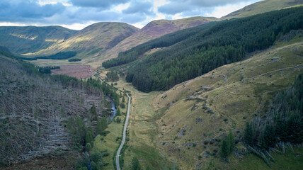 An aerial view of Glen Doll - mountains, pine forest on slopes and a road