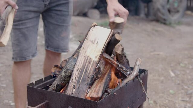 man prepares to light the fire with long cut wood. wood placed in a brazier for baking. close up image