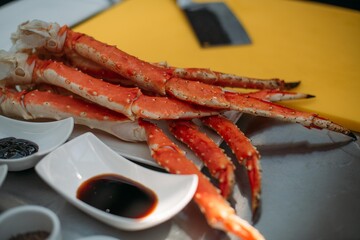 Fresh red Kamchatka crab legs on the table and ingredients in the restaurant kitchen.