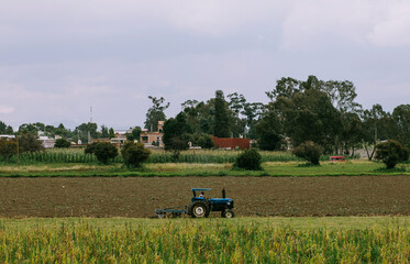 Tractor plowing the field for planting corn in a rural community in Puebla
