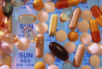 Close-up of assorted pills and capsules on a pill box