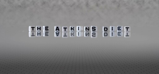 the atkins diet word or concept represented by black and white letter cubes on a grey horizon...