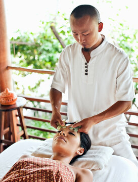 Woman Receiving Guasha Facial. Koh Samui, Thailand. A woman receives a Guasha facial, a traditional Chinese medicinal practice using jade.