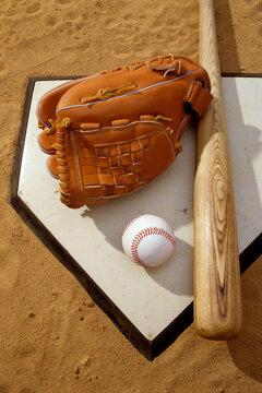 Baseball bat with a glove and a baseball on the home base