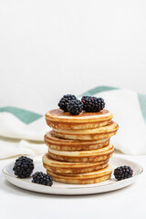 Pancakes on plate with blackberries. Healthy breakfast with fruits