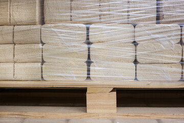 Sawdust briquettes are packed in polyethylene and placed on a wooden pallet.