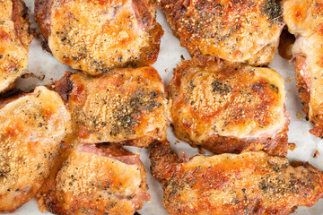Baking pan with pieces of roasted chicken covered in cheese