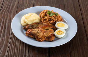 Lunch food plate. Pasta with roasted chicken, mashed and eggs. wooden background