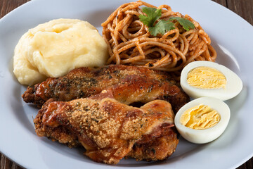 Lunch food plate. Pasta with roasted chicken, mashed and eggs. close up view