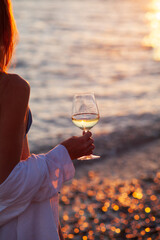 Romantic dinner near sea on sunset. Woman standing alone, waiting husband on beach sky and ocean on background. 