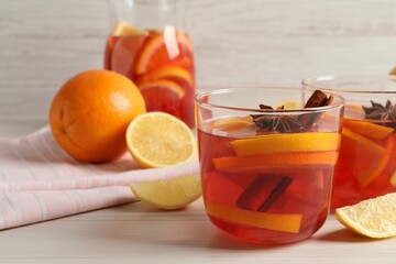 Aromatic punch drink and ingredients on white wooden table. Space for text