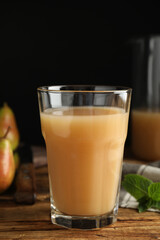 Fresh pear juice in glass on wooden table, closeup