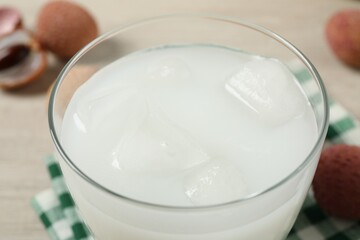 Glass with fresh lychee juice on table, closeup