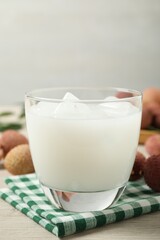 Fresh lychee juice on white wooden table, closeup