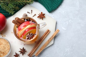 Aromatic hot mulled cider on light grey marble table, flat lay. Space for text