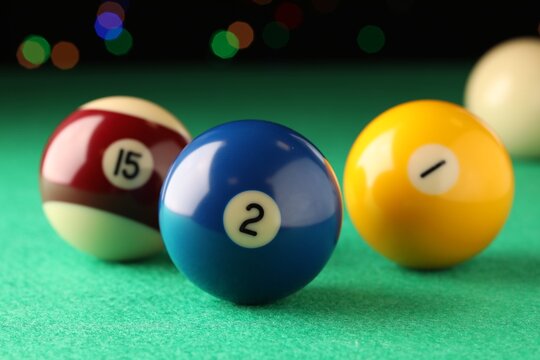 Many colorful billiard balls on green table, closeup