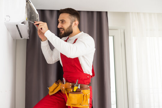 Technician repairing air conditioner on the wall