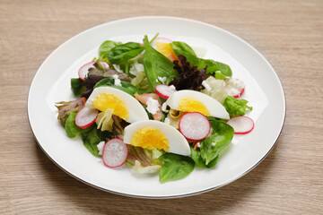 Delicious salad with boiled egg, radish and cheese on wooden table, closeup