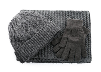 Black woolen gloves, scarf and hat on white background, top view. Winter clothes