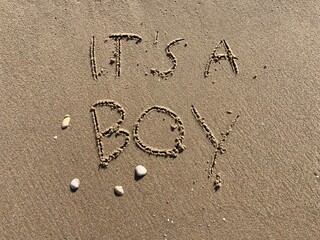 on the beach is carved with letters in the smooth sand the writing it’s a boy