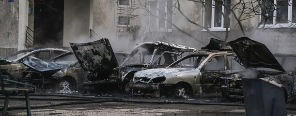 Burnt to the ground and smoking remains of civilian vehicles that came under artillery fire in Ukraine during the military escalation of hostilities and armed military aggression