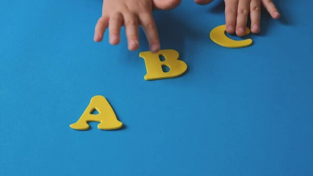 Child's hand playing with letters of the alphabet