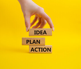 Idea Plan Action symbol. Wooden blocks with words Idea Plan Action. Beautiful yellow background. Businessman hand. Business and Idea Plan Action concept. Copy space.