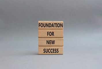 Foundation for new success symbol. Wooden blocks with words Foundation for new success. Beautiful...