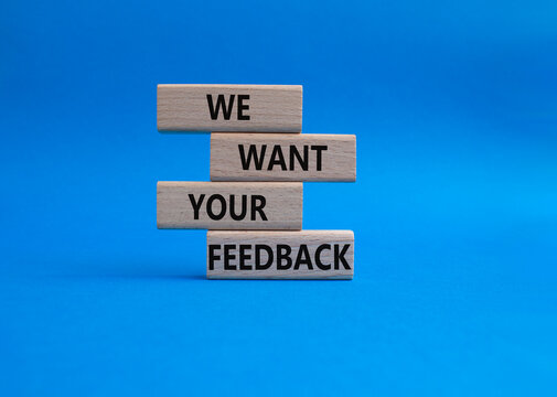 We want your feedback symbol. Wooden blocks with words We want your feedback. Beautiful blue background. We want your feedback concept. Copy space.