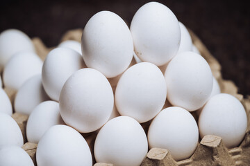 Chicken white eggs in pyramid. Stack of eggs on paper packing.