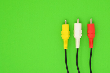 rca cable connector yellow white and red closeup on green background