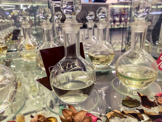 decorated transparent glass display case with perfume. perfumes in transparent flasks with a lid. creation of a fragrant flower arrangement