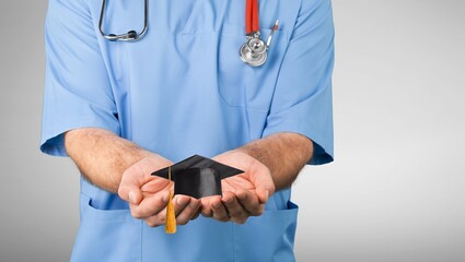 A doctor study learn with graduation gap hat in hand, clever bright genius education medicine concept.