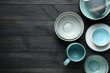 Stylish empty dishware on black wooden table, flat lay. Space for text