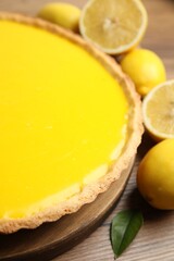Delicious homemade lemon pie and fresh fruits on wooden table, closeup