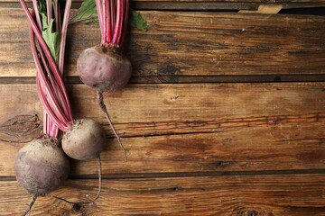 Raw ripe beets on wooden table, flat lay. Space for text