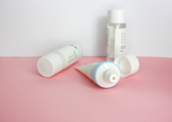 KYIV, UKRAINE - 19 AUGUST 2022: Skin care products on white and pink background. Korean cosmetics brand Round Lab cleanser, lotion and tonic. Flat lay. Selective focus. Side view.